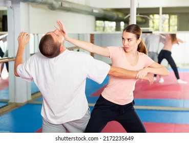 Young Woman Paired Up With Male Partner In Self Defense Training, Practicing Basic Palm Strike..