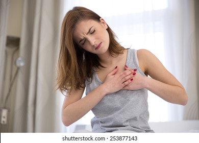 Young Woman In Pajamas Having Heart Attack