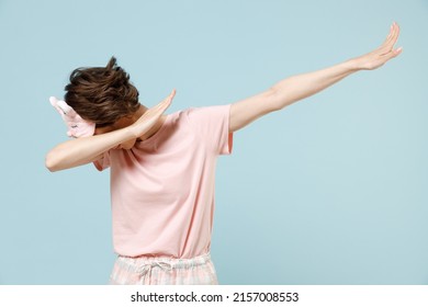 Young Woman In Pajamas Jam Sleep Eye Mask Rest Relax At Home Do Dab Hip Hop Dance Hands Move Gesture Youth Sign Cover Face Isolated On Pastel Blue Background Studio Good Mood Night Bedtime Concept.