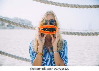 Young Woman With Papaya On The Beach