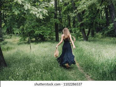 Young Woman In A Park Running Away Into The Woods