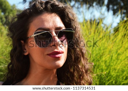 Similar – Woman with sunglasses looking at camera over garden fence