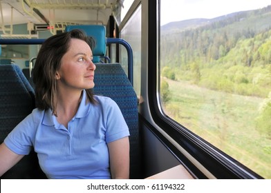 Young Woman Passenger Sitting Inside Train And Looking Trough Window