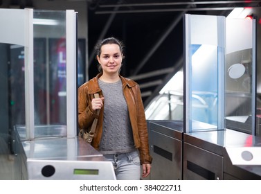 Young Woman Passing The Turnstile At Subway Station