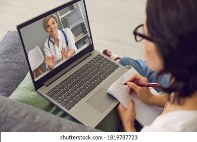 Young Woman Patient Making Notes During Online Consultation With Smiling Woman Doctor Therapist Consulting Her From Laptop. Telemedicine And Online Visit To Doctor Concept