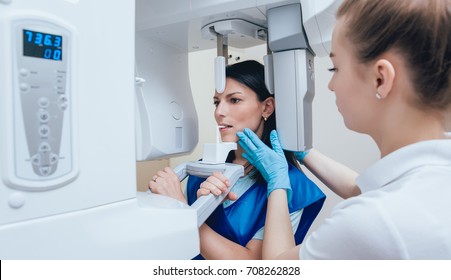 Young Woman Patient Standing In X-ray Machine. Panoramic Radiography