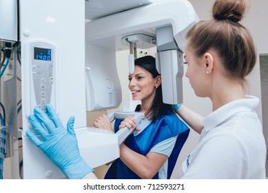 Young woman patient standing in x-ray machine. Panoramic radiography