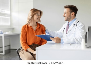 Young woman patient talking with male doctor during appointment in clinic office, free space