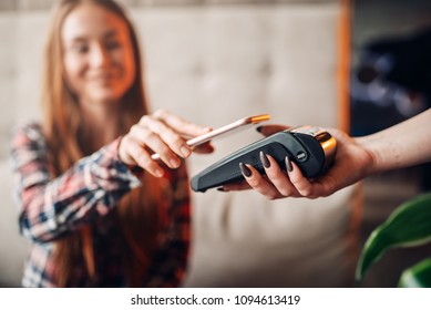 Young Woman Pay By Mobile Phone In Cafe