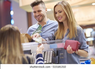 Young Woman Paying By Cash In Store
