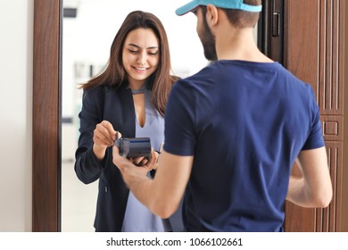 Young woman paying for delivery with credit card