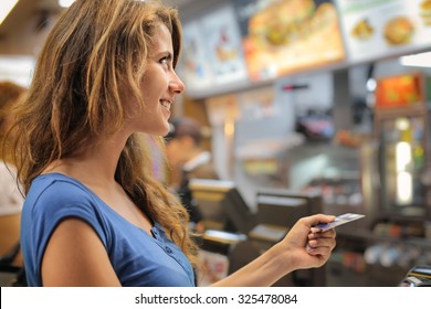 Young Woman Paying At A Fast Food Restaurant