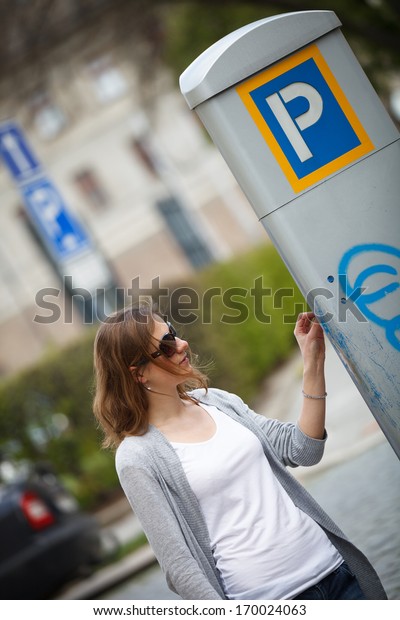 Young woman paying for\
parking