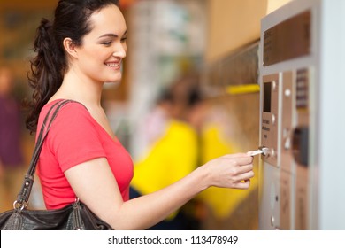 young woman paying for parking at pay station