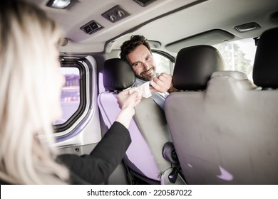 Young woman paying for the taxi