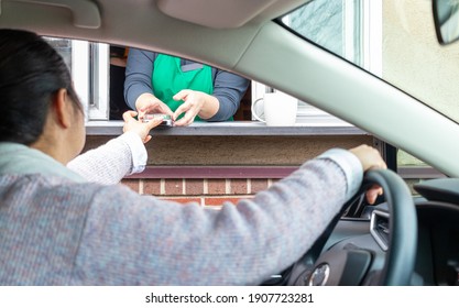 Young Woman Pays For Service Through Drive Thru