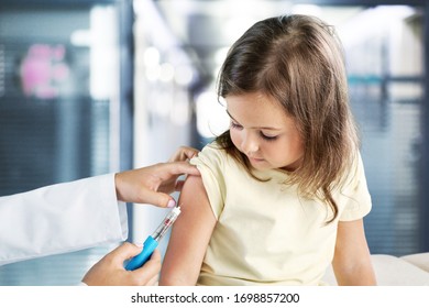 Young woman pediatrician doing vaccination of a little girl - Powered by Shutterstock