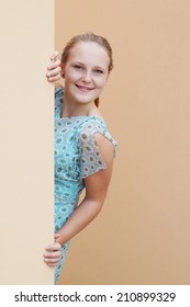 Young Woman Peeking Around Corner