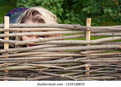 Young Woman Peeking Over  Fence