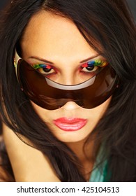 Young Woman Peeking Over Sunglasses With Fake Eyelashes