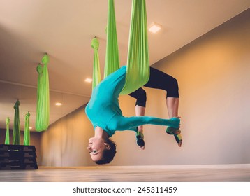 Young woman performing antigravity yoga exercise  - Powered by Shutterstock