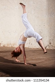Young Woman Performing A Cartwheel On Floor