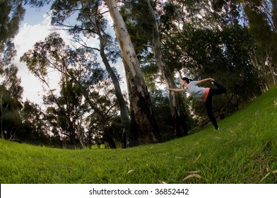 Young Woman Performing Yoga In A Park. Photo Taken With 10.5mm DX Fisheye Lens