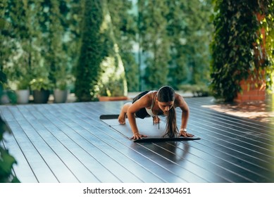 Young woman performs chaturanga dandasana. Practicing yoga alone - Powered by Shutterstock