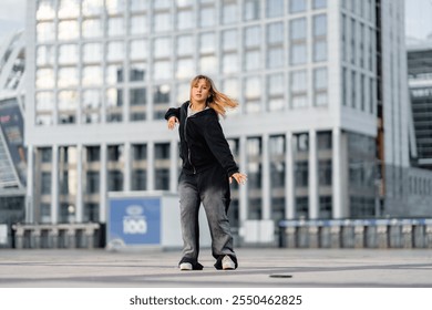 Young woman performs dance in urban setting with modern architecture - Powered by Shutterstock