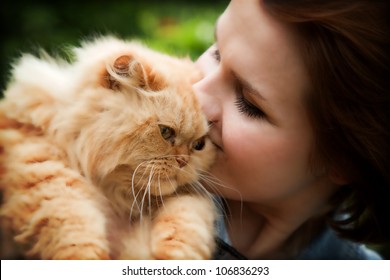 Young Woman With Persian Cat Playing. Outdoors Portrait