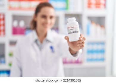 Young Woman Pharmacist Holding Pills Bottle At Pharmacy