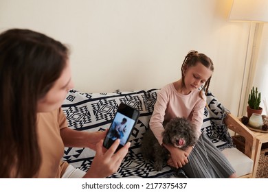 Young Woman Photographing Daughter With Little Dog