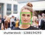 young woman picked out by face detection or facial recognition software - several other faces detected in crowd of people in background