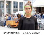 young woman picked out by face detection or facial recognition software - several other faces detected in crowd of people in background