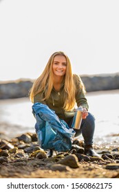 Young Woman Picking Up Aerosol Can At Beach