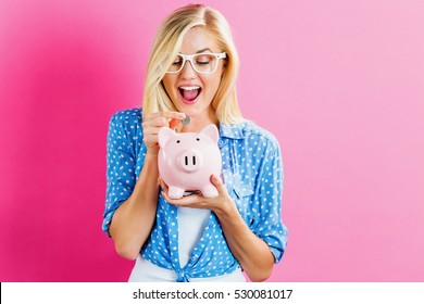 Young Woman With A Piggy Bank On A Pink Background