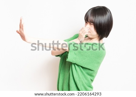 A young woman pinching her nose because of a bad smell