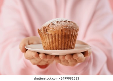 Young woman in pink hoodie with tasty muffin, closeup - Powered by Shutterstock