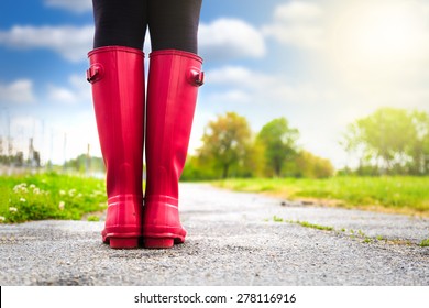 Young Woman In Pink Rain Boots Walking. Detail Of Boots.