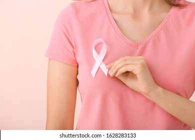 Young woman with pink ribbon on color background, closeup. Cancer awareness concept - Shutterstock ID 1628283133