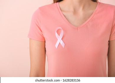 Young woman with pink ribbon on color background, closeup. Cancer awareness concept - Shutterstock ID 1628283136