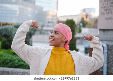 Young woman in pink scarf fights cancer disease and feels strong to overcome it. Concept: disease, fight, health care - Powered by Shutterstock