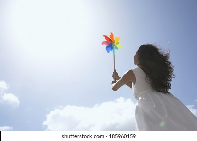 Young Woman With Pinwheel Against Sky (low Angle View)