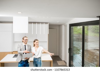 Young Woman Planning Interior With Designer Standing Together With Digital Tablet At The New Kitchen