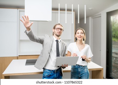 Young Woman Planning Interior With Designer Standing Together With Digital Tablet At The New Kitchen