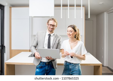 Young Woman Planning Interior With Designer Standing Together With Digital Tablet At The New Kitchen