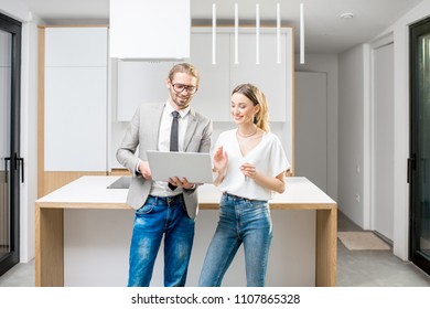 Young Woman Planning Interior With Designer Standing Together With Digital Tablet At The New Kitchen