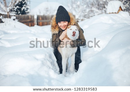 A young woman play with the dog red husky