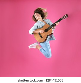 Young Woman Playing Acoustic Guitar On Color Background