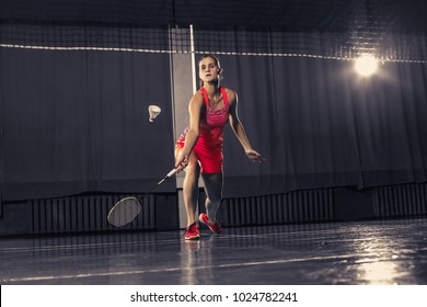 Young Woman Playing Badminton Over Gym Background